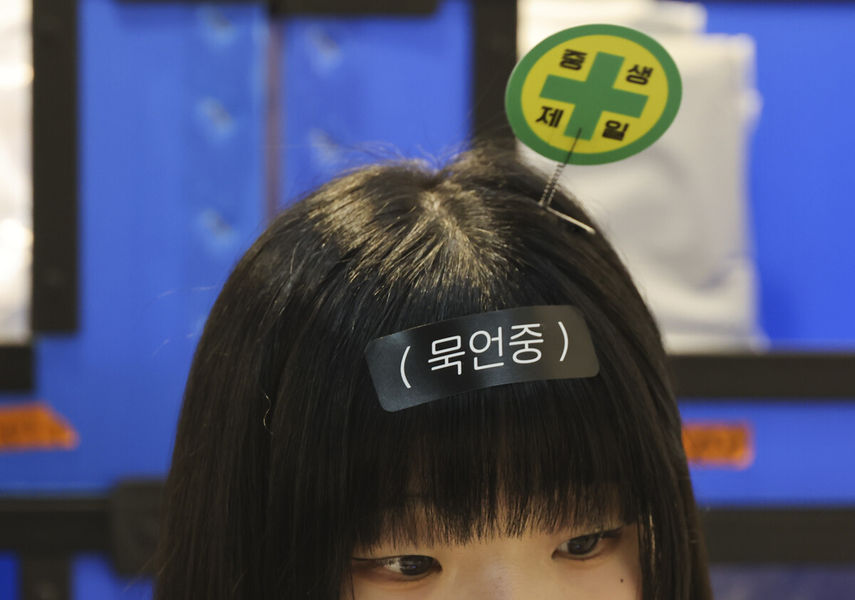 박람회 아르바이트생이 착용한 '묵언중' 글귀가 이채롭다. 사진=박정훈 기자