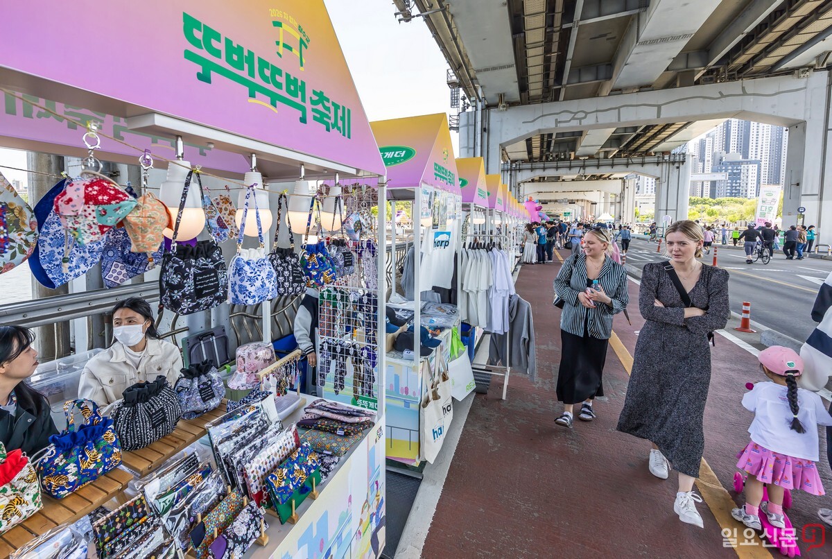 외국인들이 플리마켓 부스에서 다양한 소품과 수공예품을 구경하고 있다.