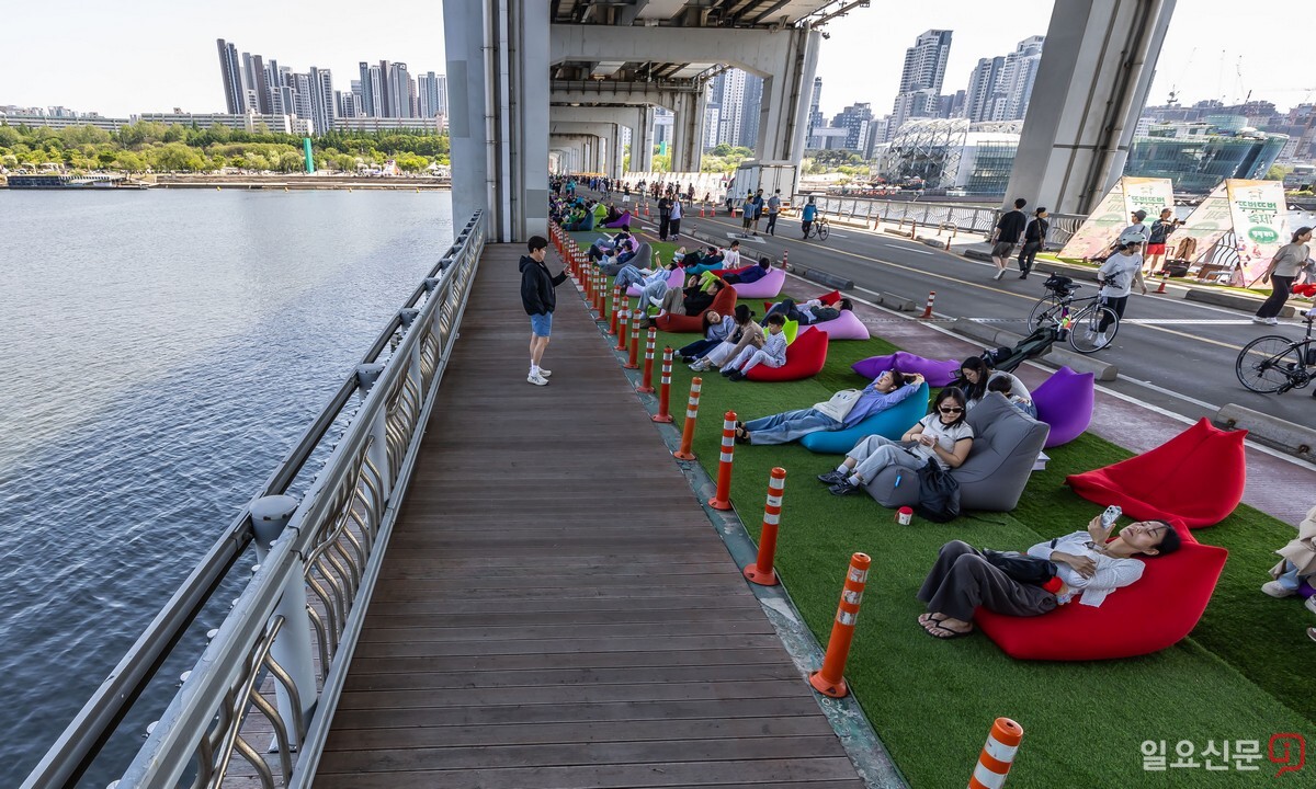 시민들이 달빛무지개 쉼터에 마련된 빈백에 기대 쉬고 있다.