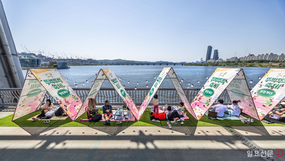 잠수교 가장자리에 설치된 텐트 쉼터에서 시민들이 봄날의 여유를 만끽하고 있다.