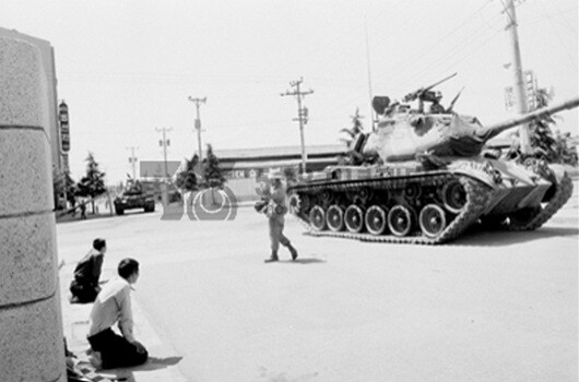 1980년 5월 광주. 무릎을 꿇은 대학생과 탱크를 몰고 가는 계엄군의 모습. 사진=5·18 기념재단 제공(이창성 아카이브)