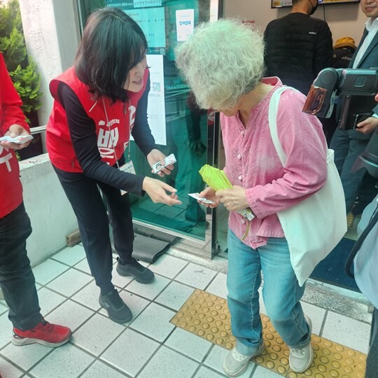 박민식 국민의힘 후보 배우자 배정혜 씨가 5월 21일 오전  콩국수데이가 열린 부산 북구 남산정복지관 입구에서 주민들에게 허리 숙여 인사하고 있다.  사진=김지영 기자