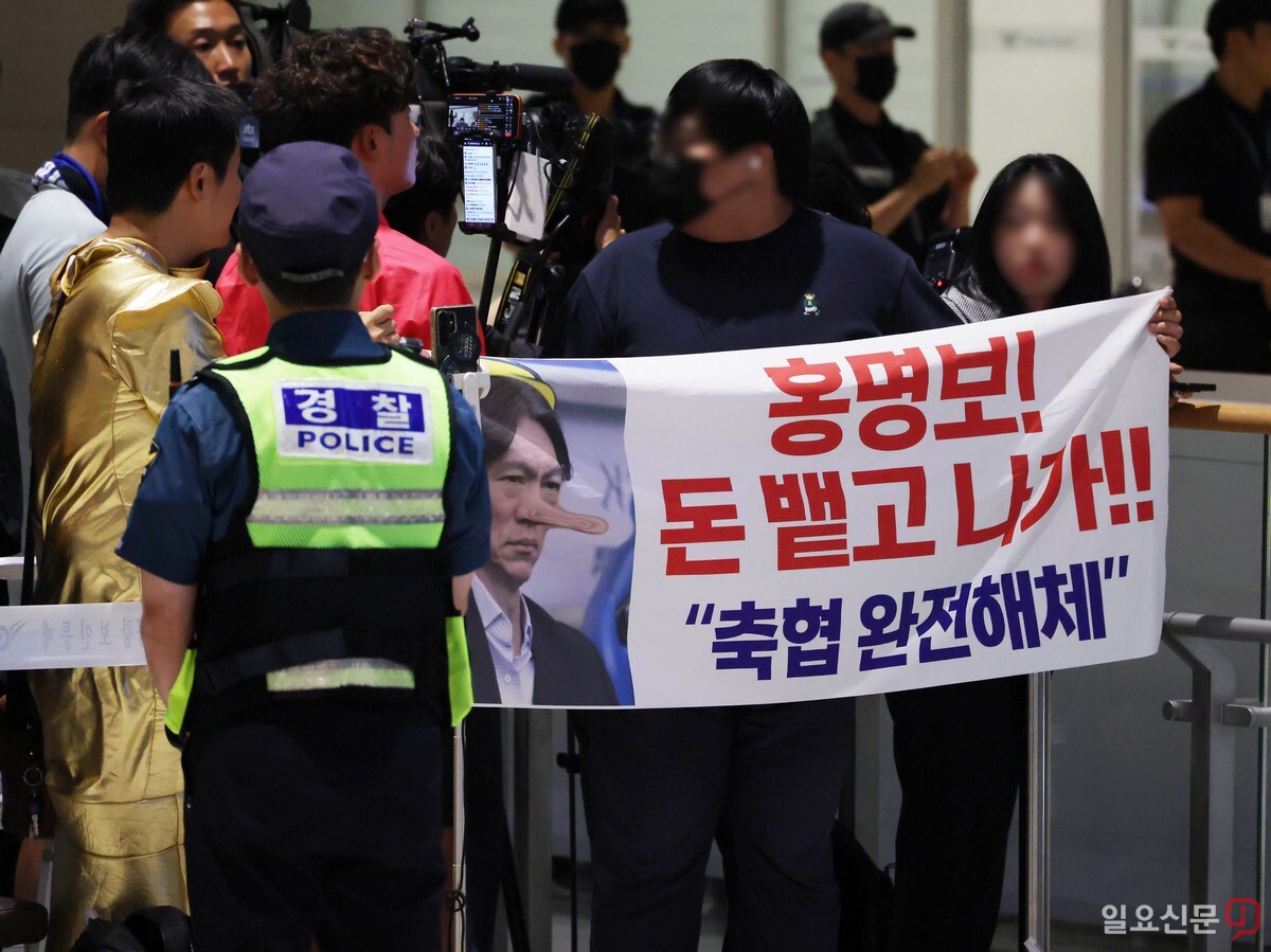 "돈 뱉고 나가." 한 축구 팬이 홍 감독을 규탄하는 현수막을 들고 항의하고 있다. 사진=최준필 기자