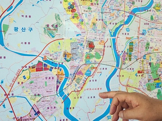 군공항 인근 부동산 시장은 아직 반도체 호재를 체감하지 못하는 분위기였다. 6월 30일 광주에서 만난 공인중개사가 부동산 지도를 가리키며 설명하고 있다. 사진=김명선 기자