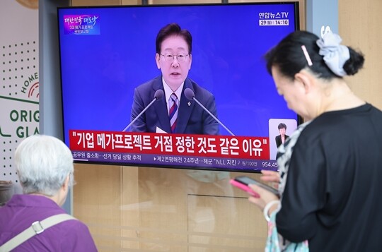 6월 29일 서울역에서 시민들이 이재명 대통령이 주재하는 3대 메가프로젝트 국민보고회를 TV 생중계를 통해 시청하고 있다. 사진=임준선 기자