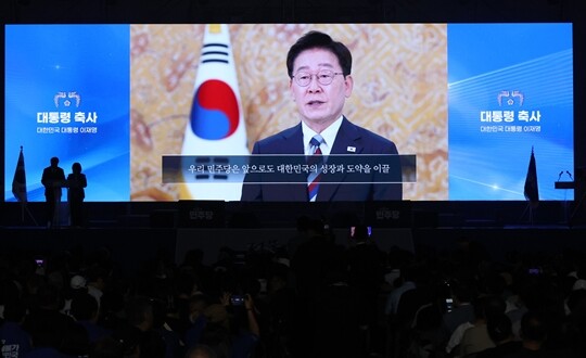8월 17일 대전 컨벤션센터에서 열린 더불어민주당 8·17 전당대회에서 이재명 대통령이 축사 영상을 통해 민주당의 단합을 강조하고 있다. 사진=이종현 기자
