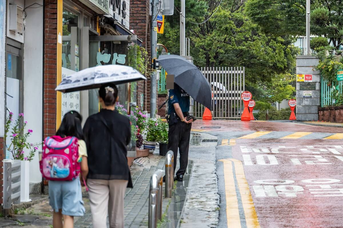 서울의 한 초등학교 정문 앞에서 한 초등학생이 어머니의 손을 잡고 하교하고 있는 모습. 사진=최준필 기자