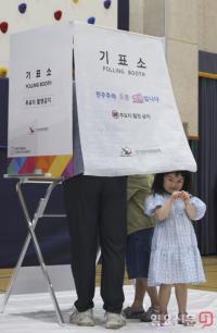 '부모님 따라 투표소 방문한 어린이'